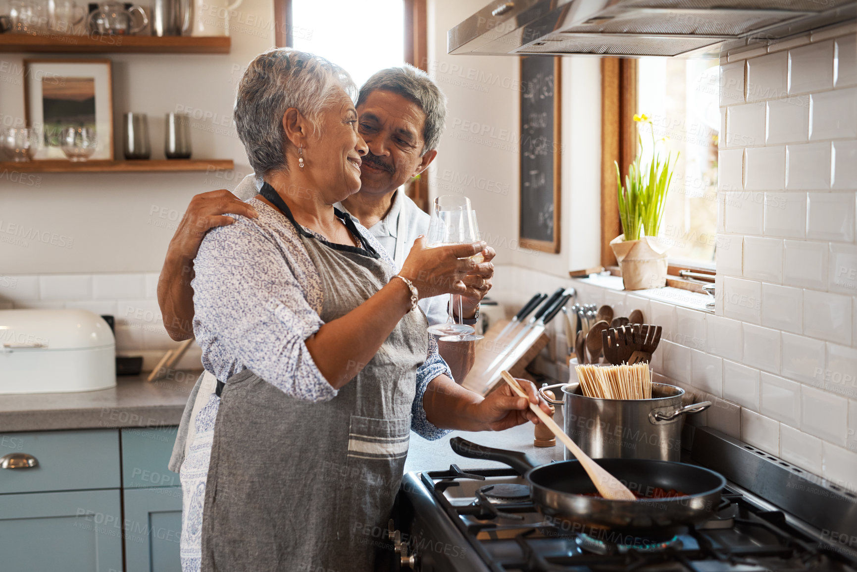 Buy stock photo Cheers, wine and old couple at in kitchen cooking food together at stove with smile, love and romance. Toast, drinks and senior woman with man, glass and happiness to make dinner meal in retirement