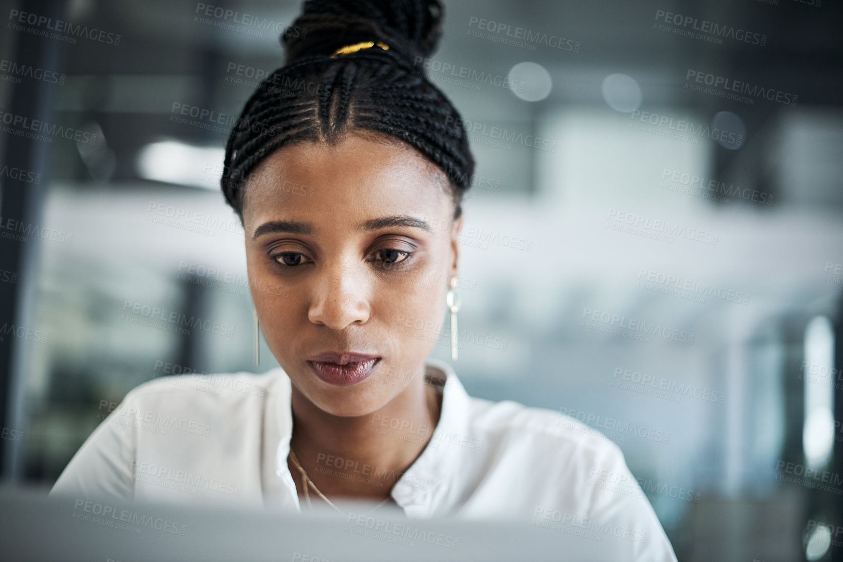 Buy stock photo Shot of an attractive young businesswoman sitting alone in her office and using her laptop