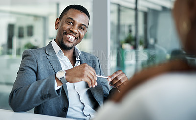 Buy stock photo Shot of a handsome young businessman sitting in the office with a coworker and having a meeting