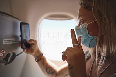 Buy stock photo Shot of  a young woman taking a selfie in the aeroplane
