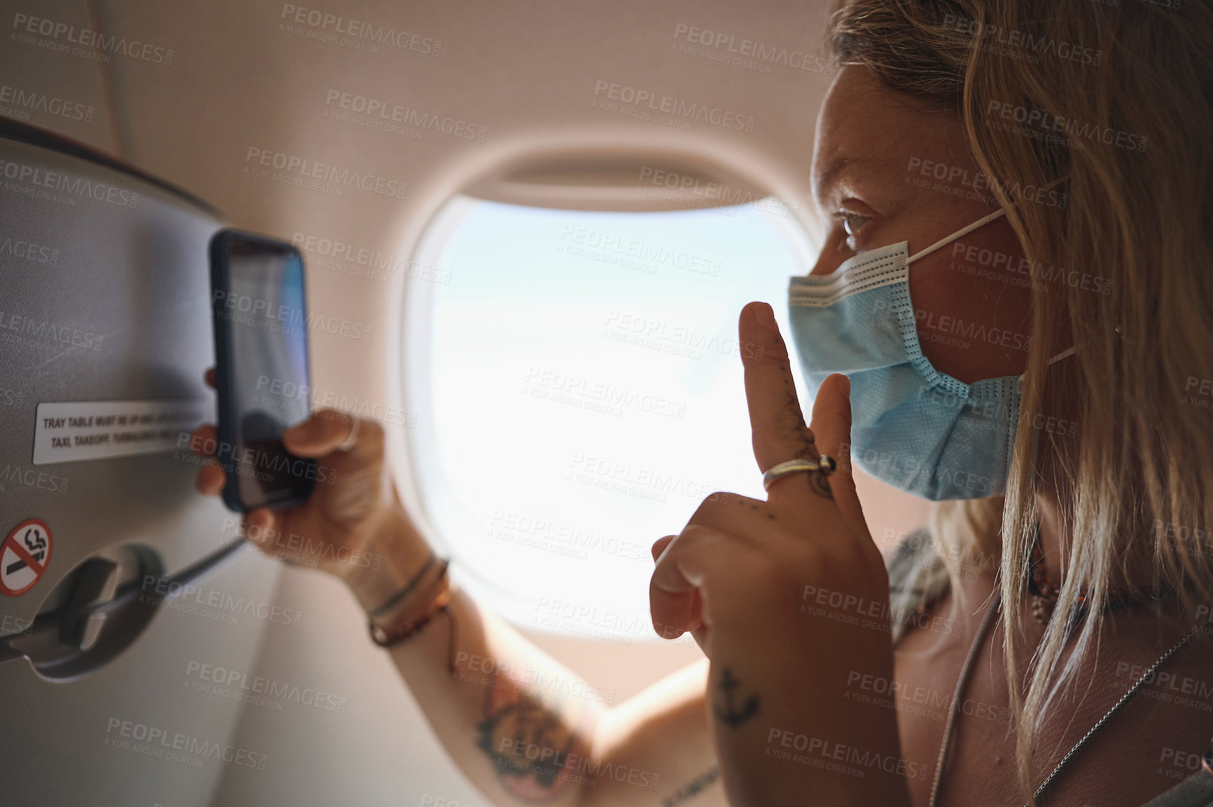 Buy stock photo Shot of  a young woman taking a selfie in the aeroplane