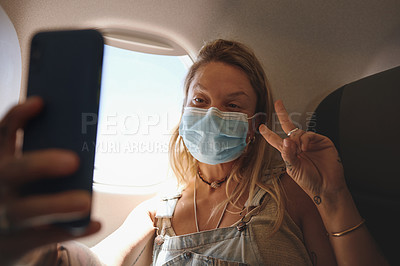 Buy stock photo Shot of  a young woman taking a selfie in the aeroplane