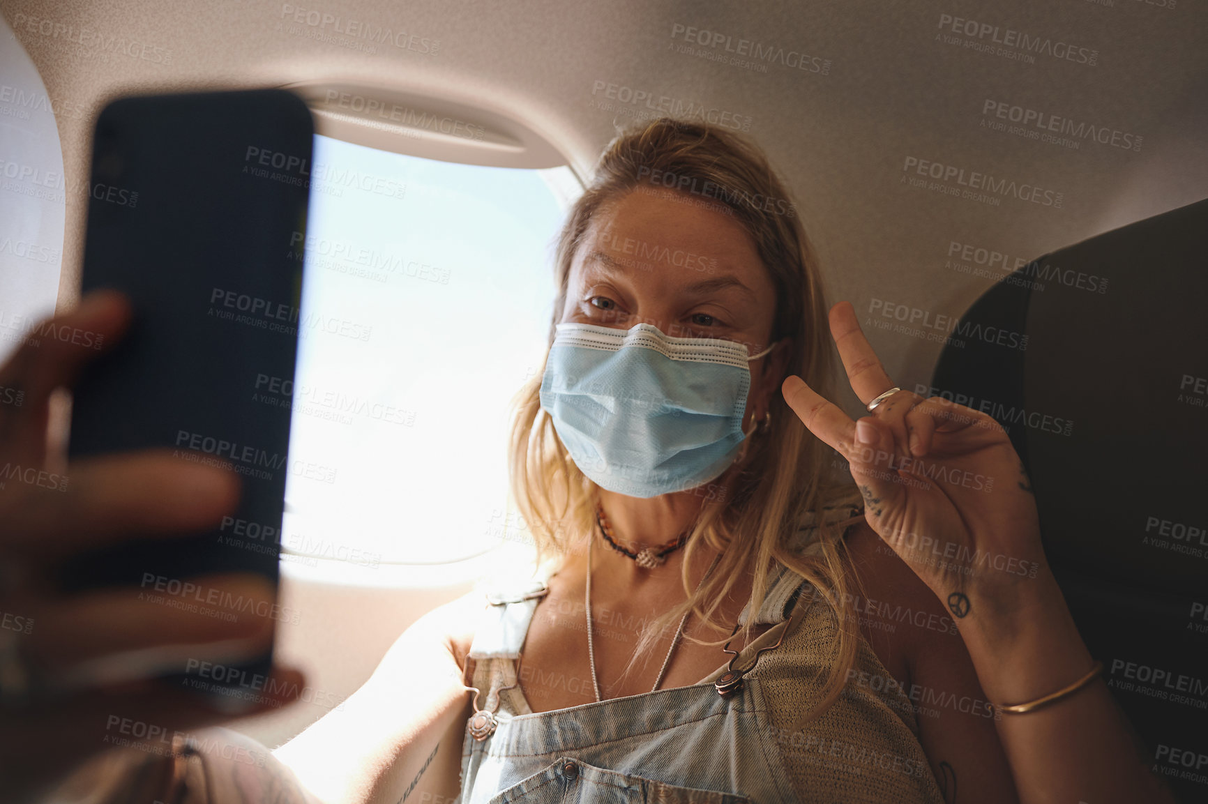 Buy stock photo Shot of  a young woman taking a selfie in the aeroplane