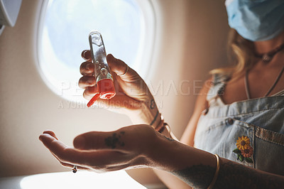 Buy stock photo Cropped shot of a woman sanitising her hands in the aeroplane