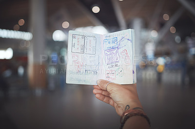 Buy stock photo Cropped shot of a woman showing her passport stamps at the airport