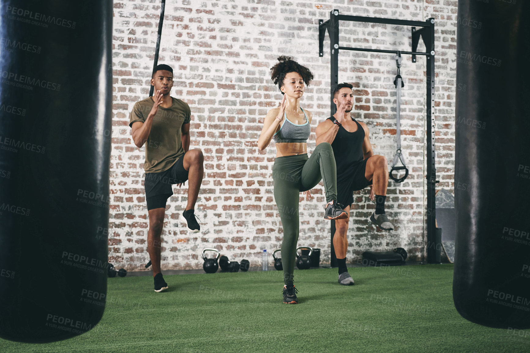 Buy stock photo Shot of a fitness group doing high knees while working out at the gym