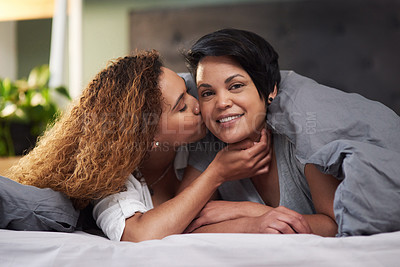 Buy stock photo Shot of an affectionate couple lying in bed together