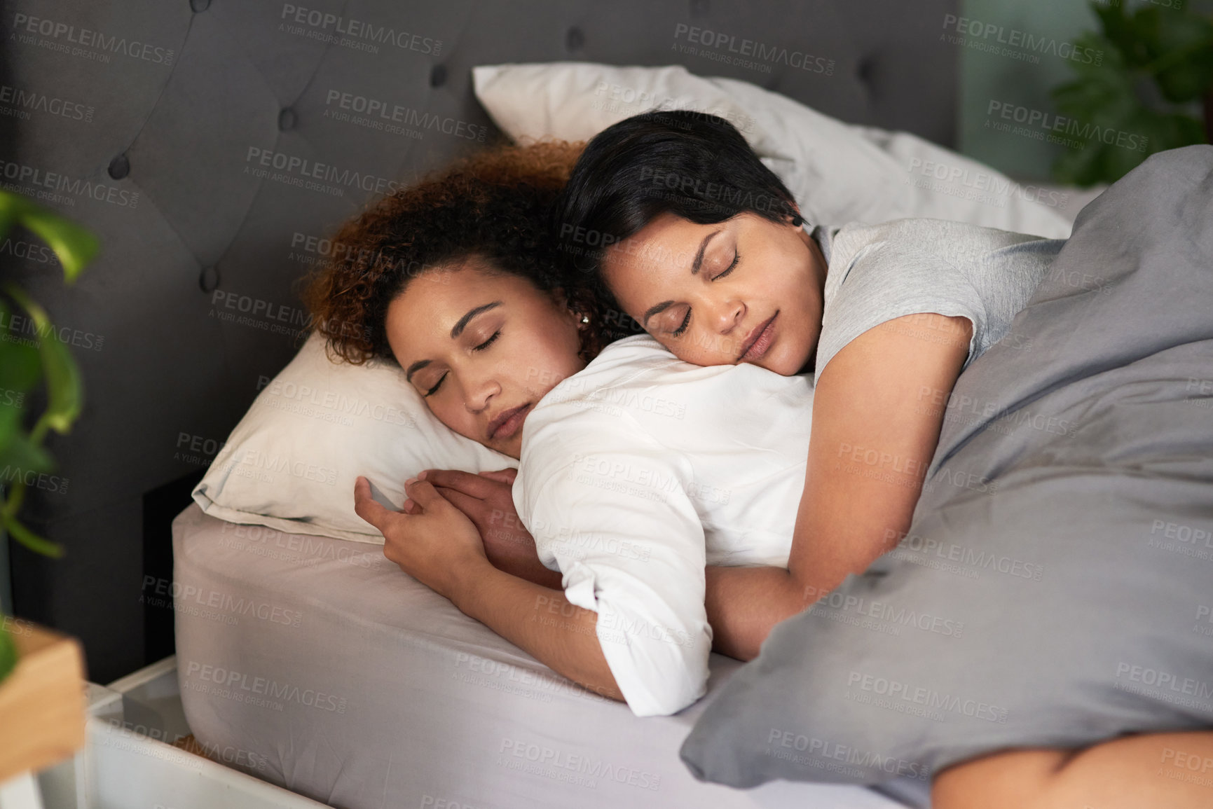 Buy stock photo Shot of an affectionate couple sleeping in their bed