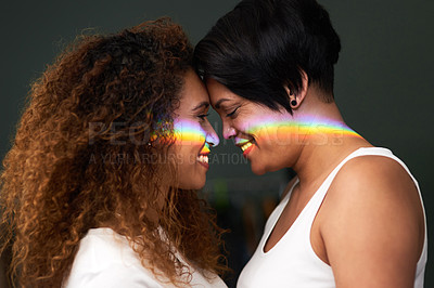 Buy stock photo Shot of an affectionate couple standing together at home with a rainbow lens flare over their faces