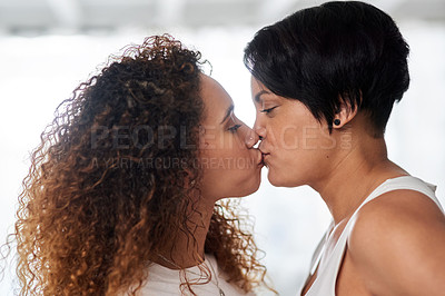 Buy stock photo Cropped shot of an affectionate couple sharing a kiss at home