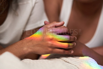 Buy stock photo Defocused shot of a young couple holding hands while lying in bed together