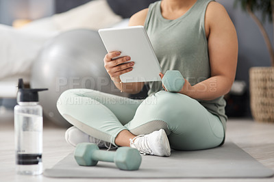 Buy stock photo Closeup shot of an unrecognisable woman using a digital tablet while exercising at home