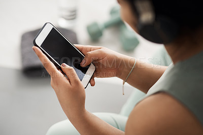 Buy stock photo Closeup shot of an unrecognisable woman using a cellphone while exercising at home