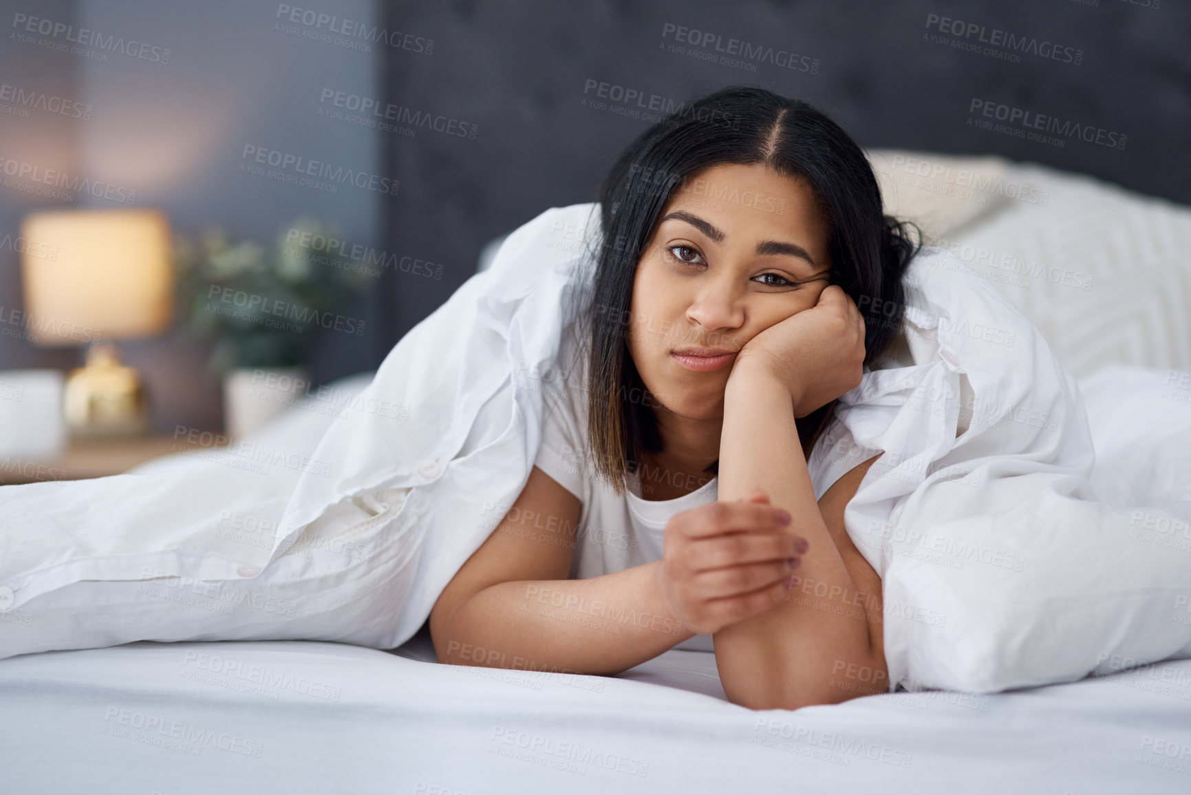 Buy stock photo Bored tired woman suffering from insomnia lying in bed looking exhausted. Unhappy young female in comfortable white bed with cozy, warm sheets being lazy on a weekend morning