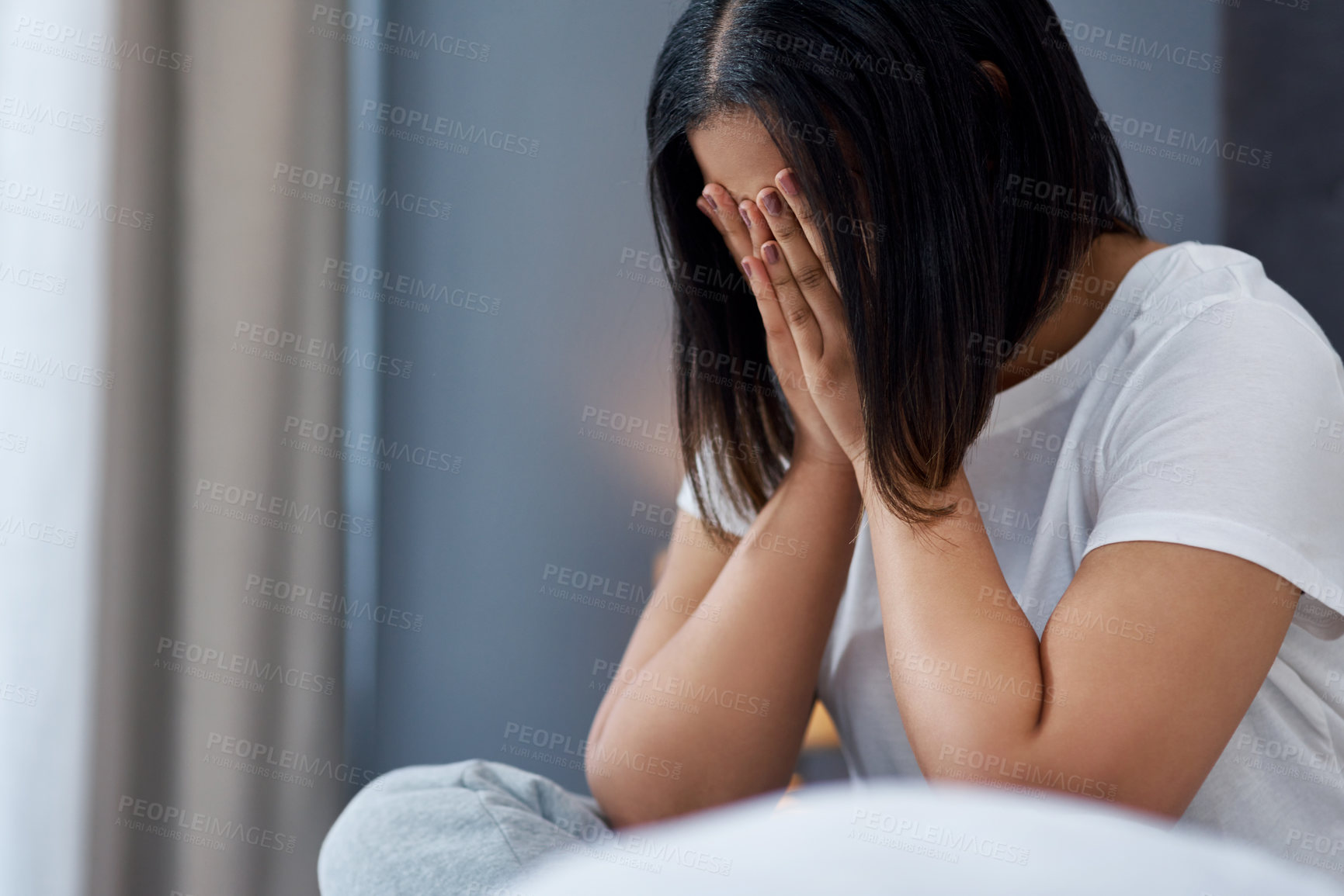 Buy stock photo Shot of a young woman feeling unhappy in bed at home