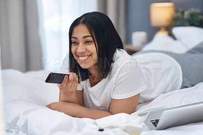 Buy stock photo Shot of a young woman watching television from the comfort of her warm bed