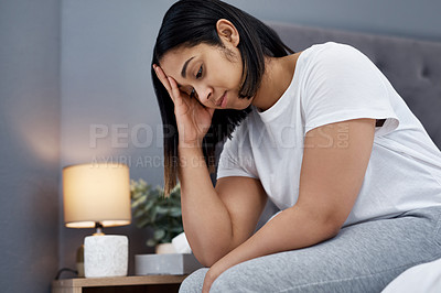 Buy stock photo Shot of a young woman feeling unhappy in bed at home