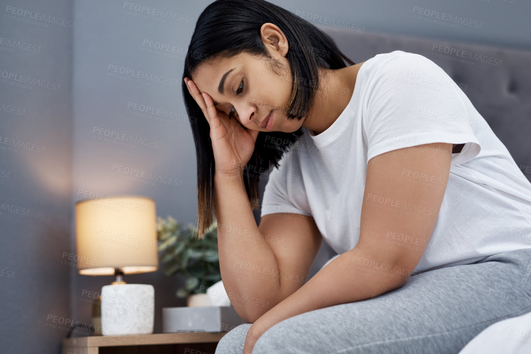 Buy stock photo Shot of a young woman feeling unhappy in bed at home