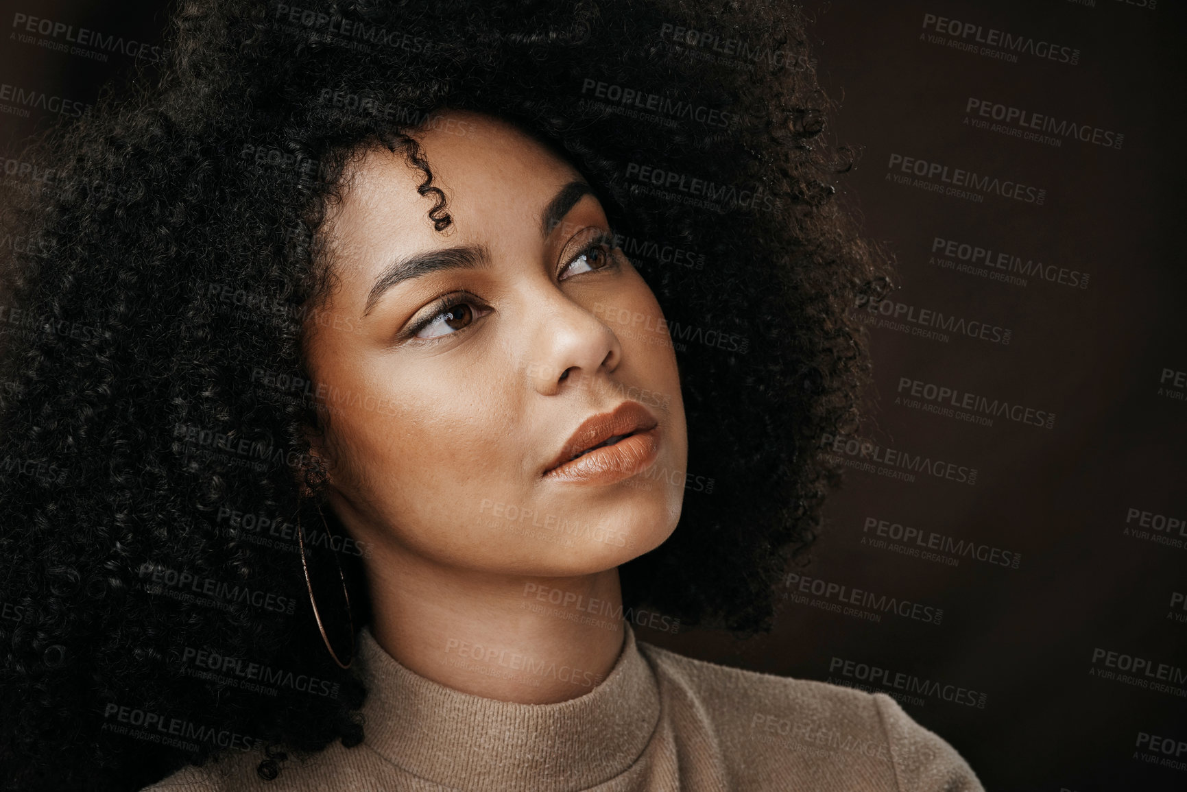 Buy stock photo Cropped shot of an attractive young woman looking thoughtful while posing in studio against a dark background