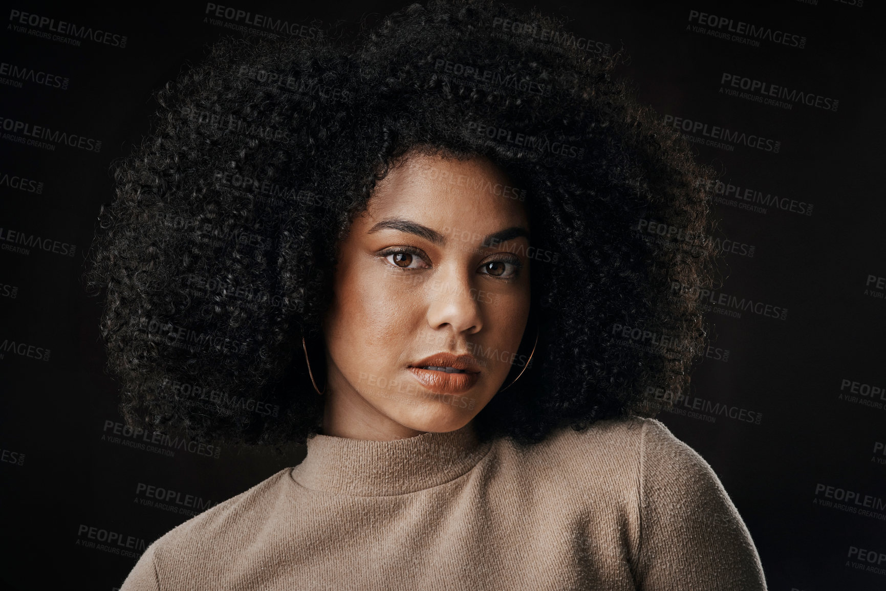 Buy stock photo Cropped portrait of an attractive young woman posing in studio against a dark background