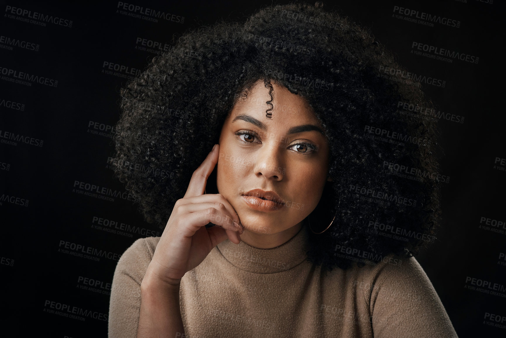 Buy stock photo Cropped portrait of an attractive young woman posing in studio against a dark background