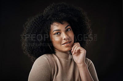 Buy stock photo Cropped portrait of an attractive young woman posing in studio against a dark background