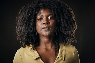 Buy stock photo Cropped portrait of an attractive young woman posing in studio against a dark background