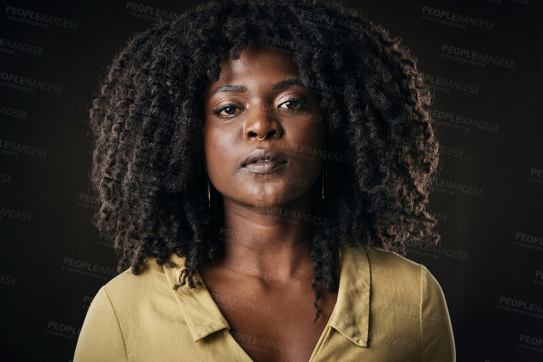 Buy stock photo Cropped portrait of an attractive young woman posing in studio against a dark background