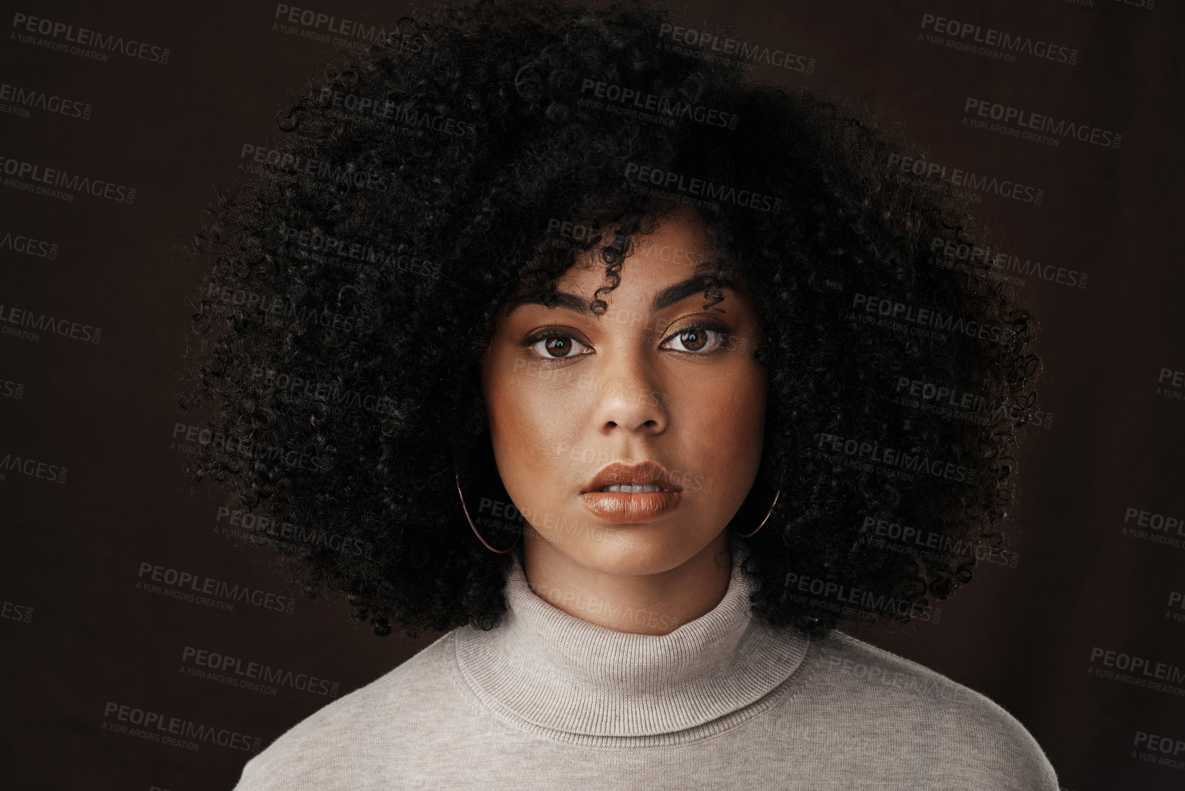 Buy stock photo Cropped portrait of an attractive young woman posing in studio against a dark background