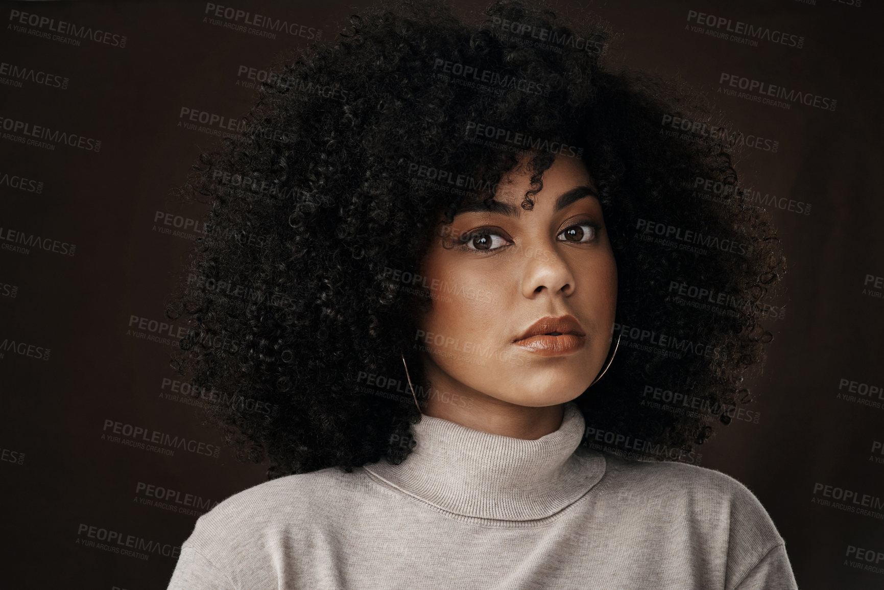 Buy stock photo Cropped portrait of an attractive young woman posing in studio against a dark background