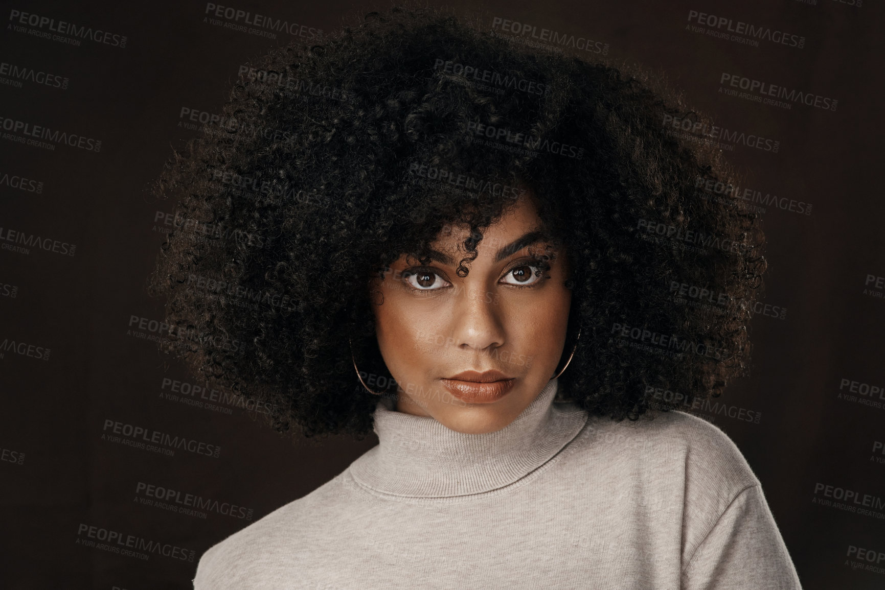 Buy stock photo Cropped portrait of an attractive young woman posing in studio against a dark background