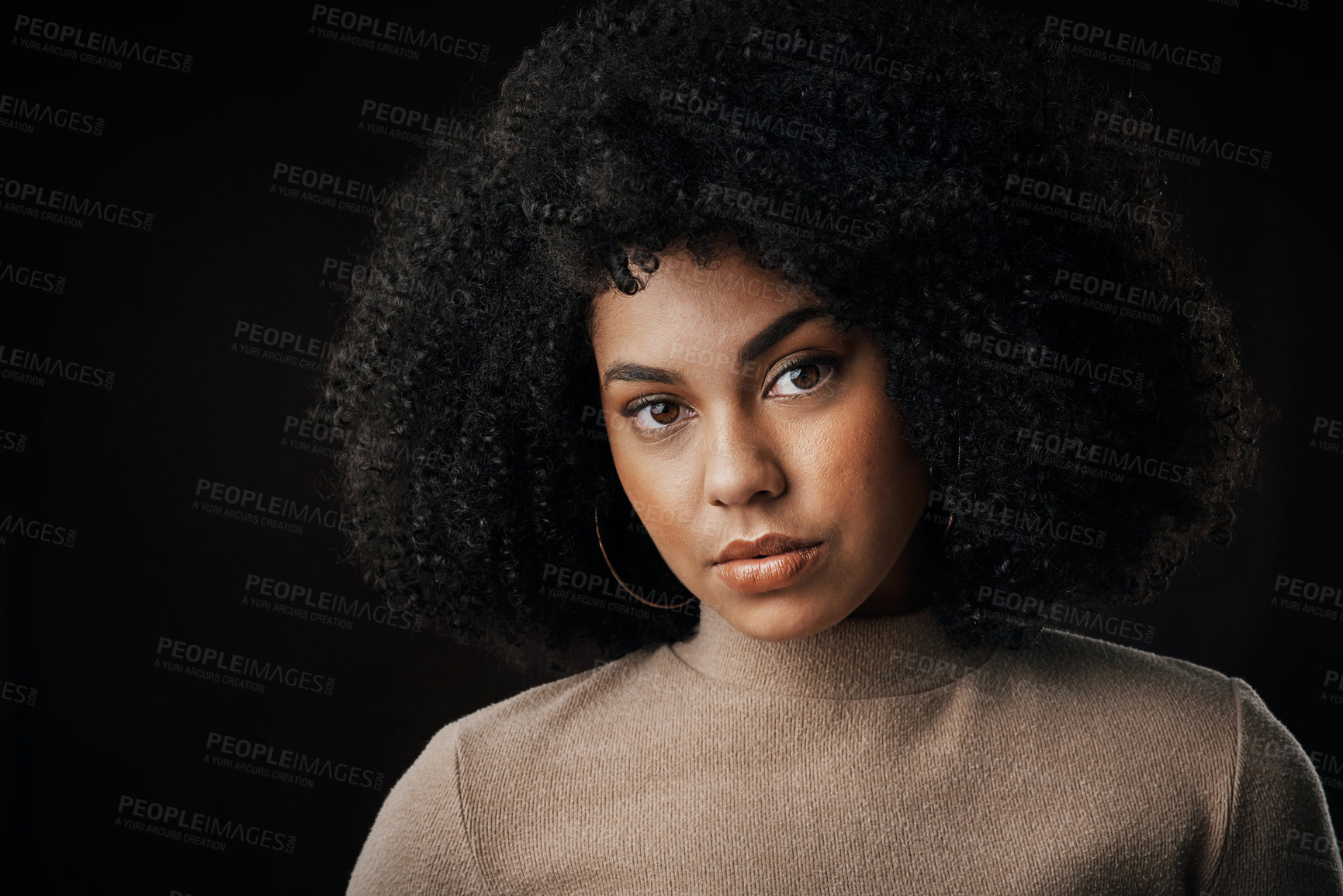 Buy stock photo Cropped portrait of an attractive young woman posing in studio against a dark background