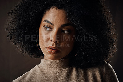Buy stock photo Cropped shot of an attractive young woman looking thoughtful while posing in studio against a dark background