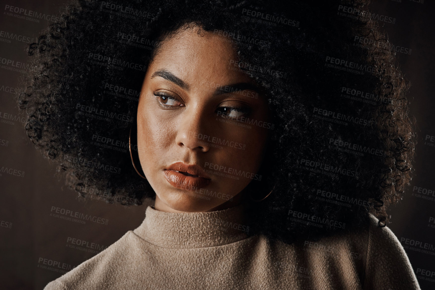 Buy stock photo Cropped shot of an attractive young woman looking thoughtful while posing in studio against a dark background