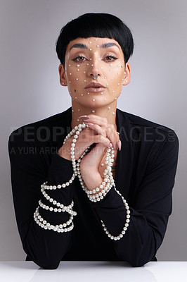 Buy stock photo Studio portrait of a beautiful young woman with pearls on her face posing against a grey background