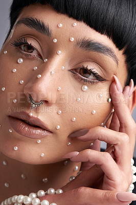 Buy stock photo Studio shot of a beautiful young woman with pearls on her face posing against a grey background