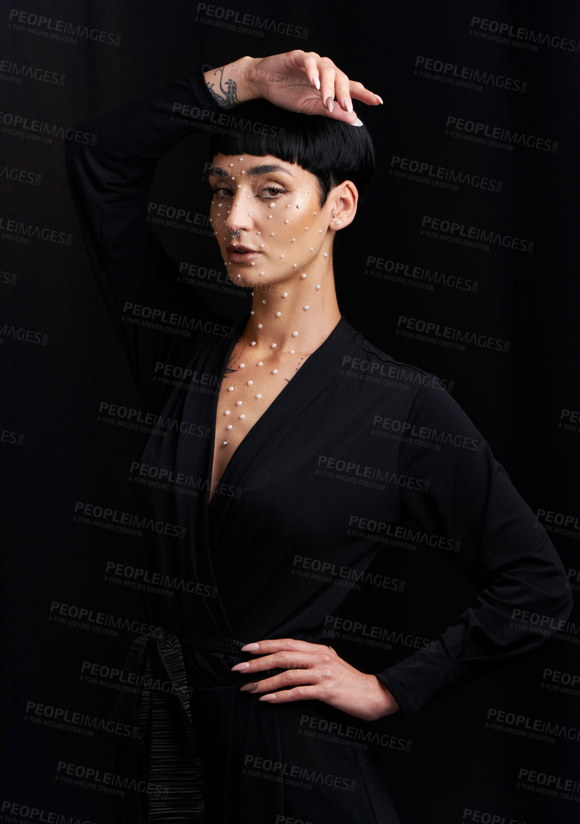 Buy stock photo Studio portrait of a beautiful young woman with pearls on her face posing against a black background