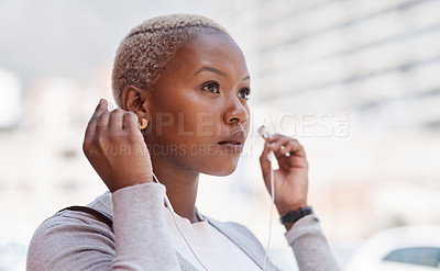 Buy stock photo Music, thinking and vision with a business black woman in the city on her morning commute into work. Mindset, future and earphones with a young female employee streaming audio in an urban town