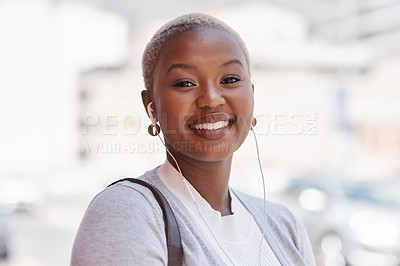Buy stock photo Portrait of a young businesswoman wearing earphones while out in the city