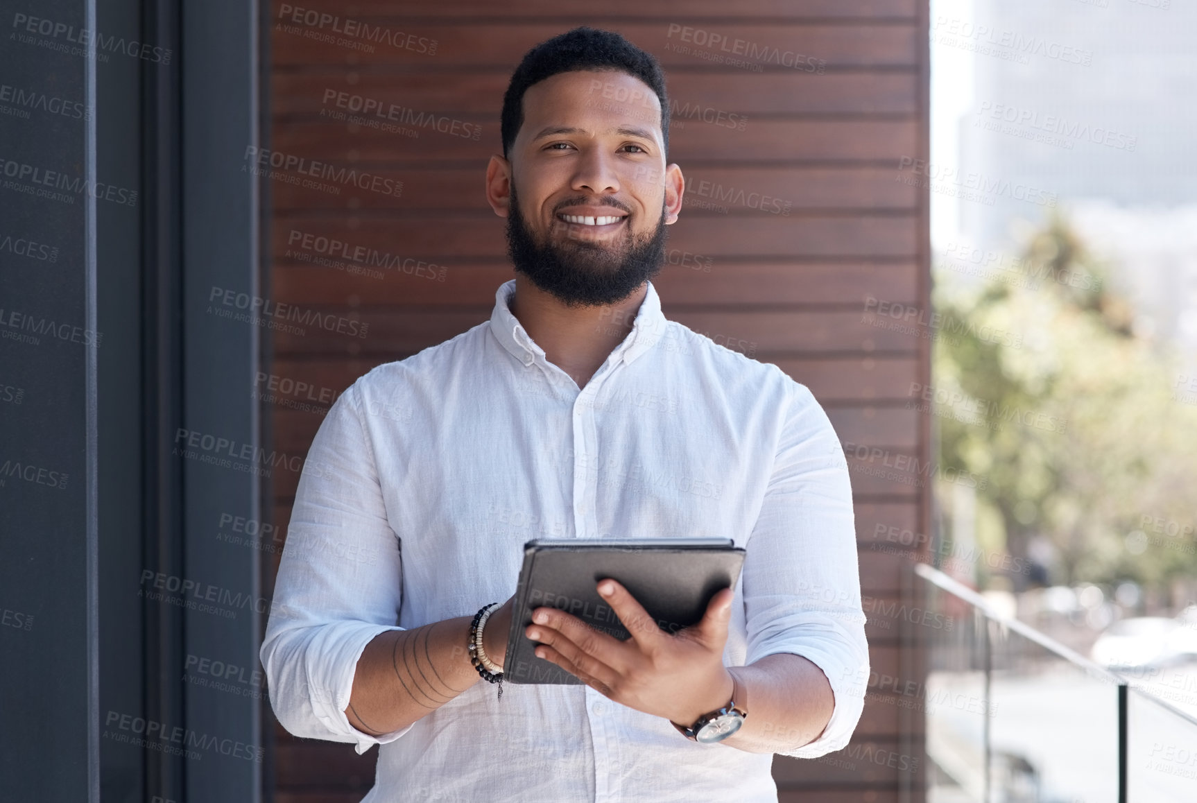 Buy stock photo Portrait of a young businessman using a digital tablet outside an office