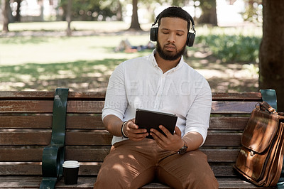 Buy stock photo Business man, headphones and outdoor with a tablet on a park bench for a break with internet. Male digital nomad and person in nature while streaming and listening to music on a audio app to relax