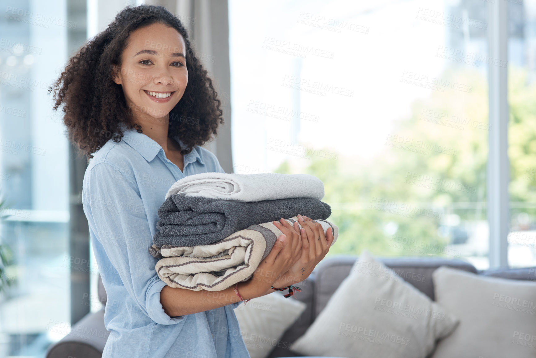Buy stock photo Portrait, laundry and cleaning with an african woman in her apartment holding fresh towels during housework. Smile, fabric and washing with a happy young female cleaner in the living room of her home