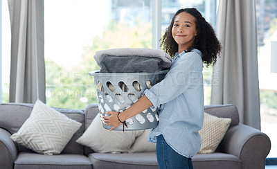 Buy stock photo Portrait, laundry and spring cleaning with a woman in the living room of her home carrying a basket. Happy, smile and housework with a young female cleaner carrying fresh washing in her apartment