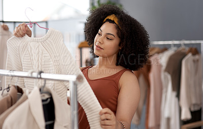 Buy stock photo Shot of a young woman shopping for clothes inside a store