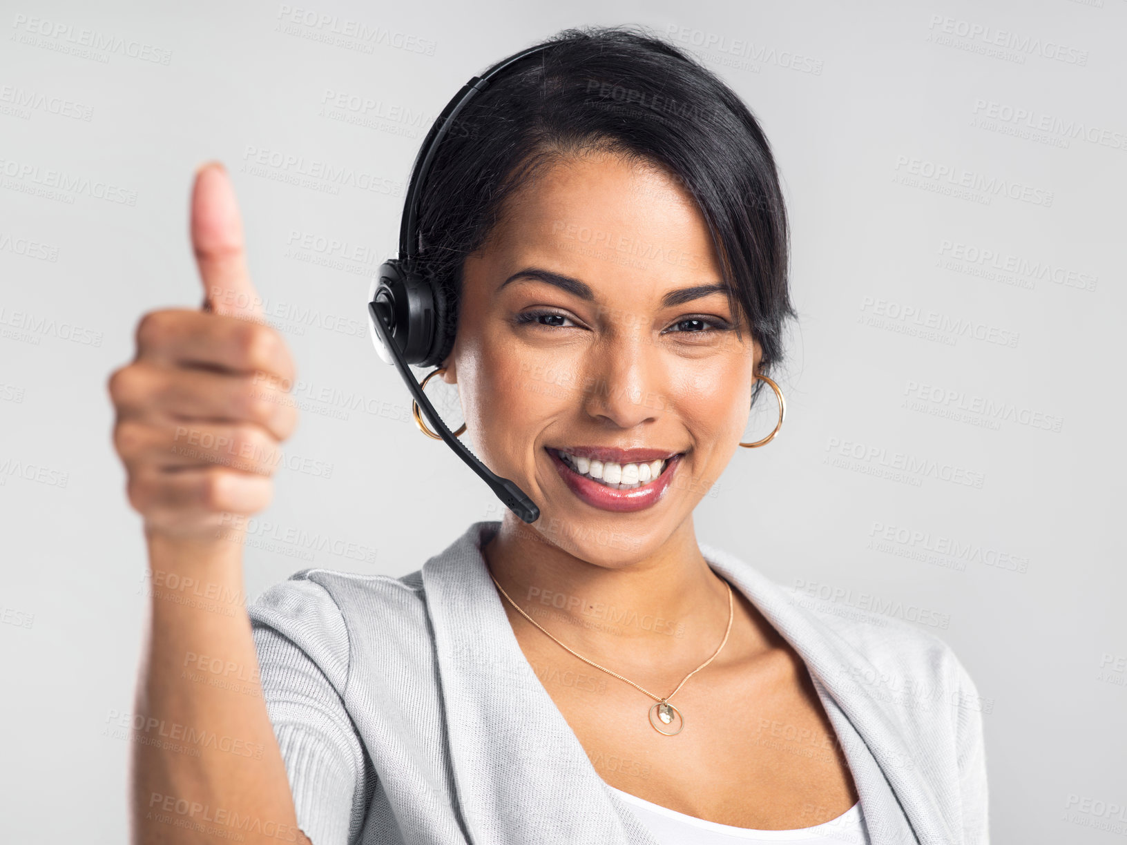 Buy stock photo Studio shot of a young businesswoman using a headset and giving a thumbs up against a grey background