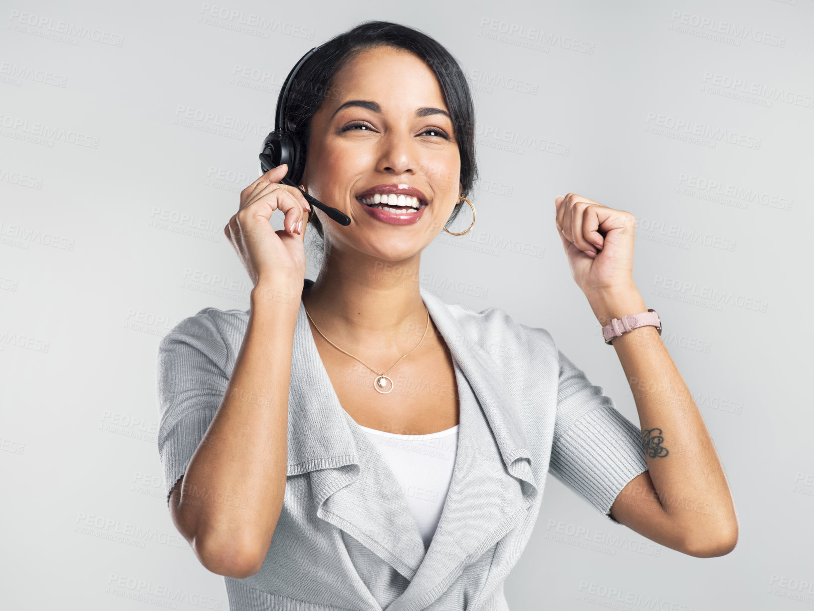Buy stock photo Studio shot of a confident young businesswoman using a headset and cheering against a grey background