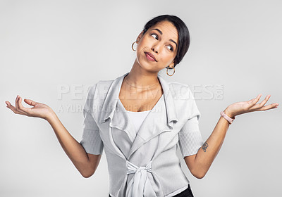 Buy stock photo Studio shot of a young businesswoman shrugging her shoulders against a grey background