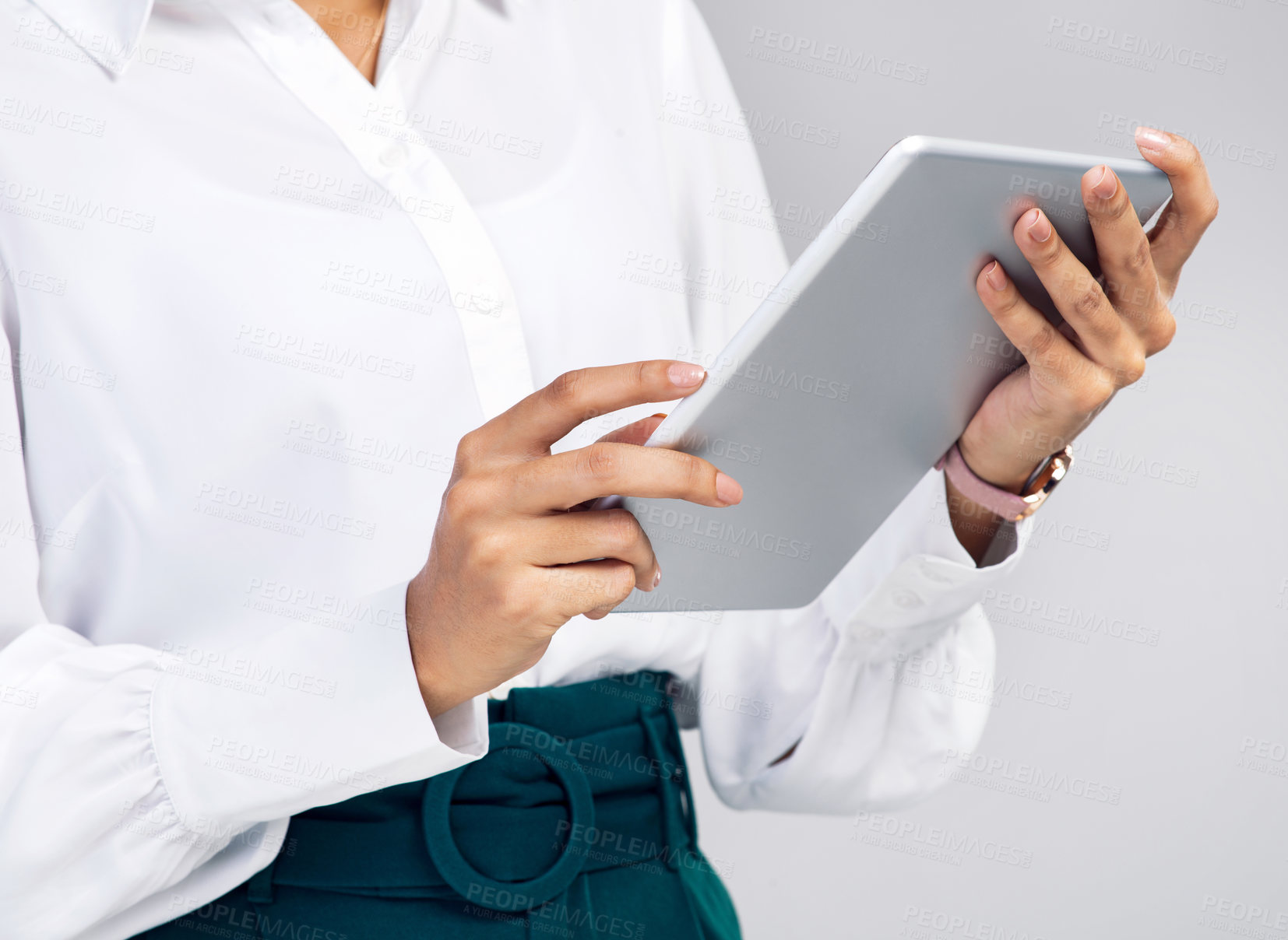 Buy stock photo Studio shot of an unrecognisable businesswoman using a digital tablet against a grey background