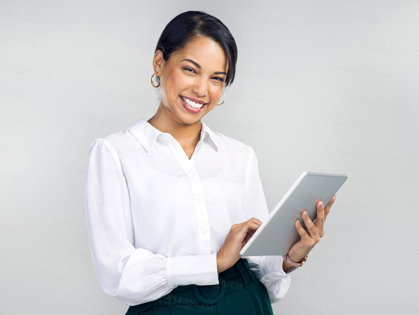 Buy stock photo Studio shot of a young businesswoman using a digital tablet against a grey background