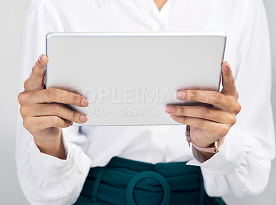 Buy stock photo Studio shot of an unrecognisable businesswoman using a digital tablet against a grey background